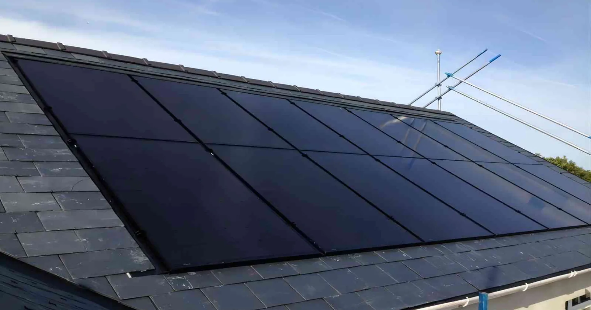 Black solar PV panels fitted flush to a slate roof on a UK house